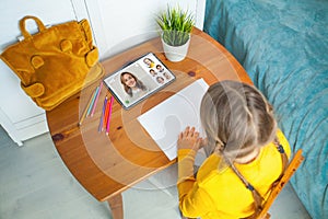 Little schoolgirl studying homework math during her online lesson at home, online education concept, home schooler