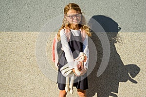 The little schoolgirl took her toy to school with her.