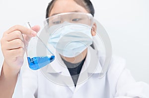 A little scientist is looking at blue liquid chemical in beaker isolated