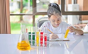 little scientist looking through a microscope and test tubes filled with chemicals for learning about science and experiments