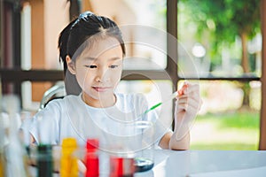 little scientist looking through a microscope and test tubes filled with chemicals for learning about science and experiments