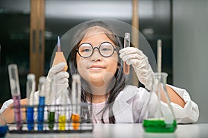 Little scientist use dropper to making experiment in chemical laboratory photo