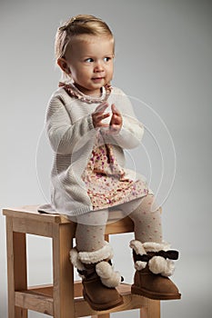 Little seated girl is expecting to clap her hands