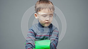 Little serious boy in protective gloves and glasses