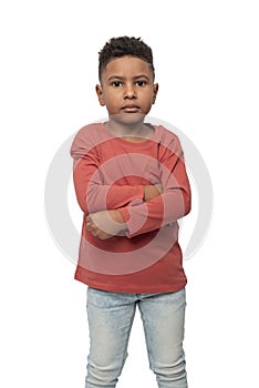 Little serious dark skinned African  boy with arms acrossing, isolated