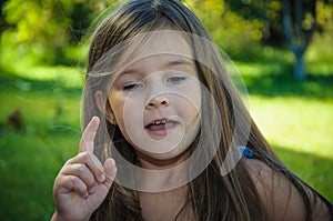 Little serious girl talking gesture hand up photo