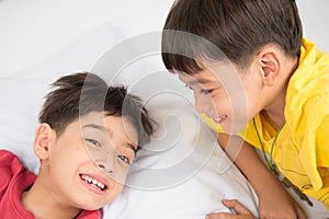 Little sibling boy lay on the pillow on the floor together