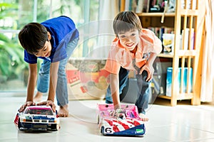 Little sibling boy playing car toy race together