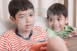 Little sibling boy playing game on mobile together at home
