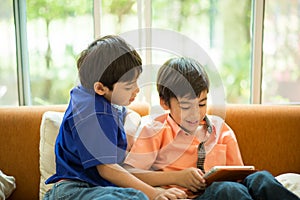 Little sibling boy playing game on mobile together house living room