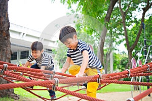 Little sibling boy playing together at playground