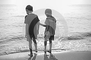 Little sibling boy standing on the beach together