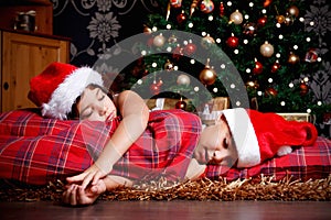 Little siblings asleep while waiting for gifts