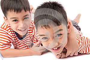 Little siblings boy brother smiling laying down together with happy face