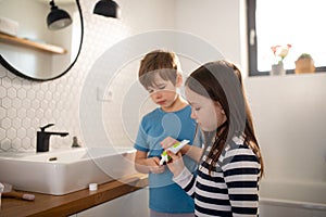 Little siblings brushing teeth in bathroom, morning routine concept.