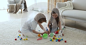 Little siblings play different toys together at home