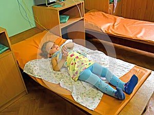 The little sick girl on treatment in a physiotherapeutic office