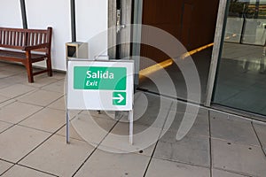 A Little Sign Board to Show Exit Way Both in English and Spanish (Bilingual)