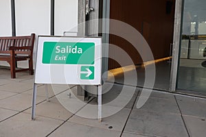 A Little Sign Board to Show Exit Way Both in English and Spanish (Bilingual)