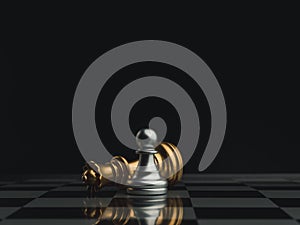 A little silver pawn chess piece standing with the win near a fallen golden queen chess piece on a chessboard on dark background.