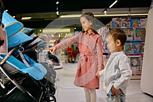 Little sister with brother walking at department store for newborns