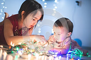 Little sisters having fun at home with chrismas lights
