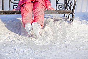 Little skater's legs standing on winter ice rink