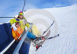 Little skier boy with mother lift on mountain