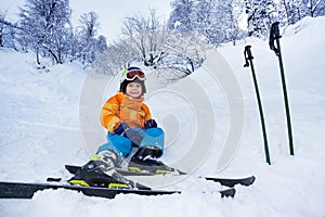 Little skier boy rest in snow wear ski outfit