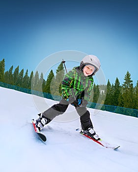 Little skier going down from snowy hill