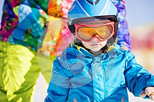 Little skier wearing ski helmet and goggles
