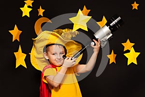 Little sky watcher looking through a telescope