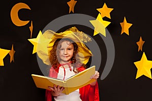 Little sky watcher studying stars with big book
