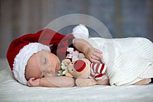 Little sleeping newborn baby boy, wearing Santa hat