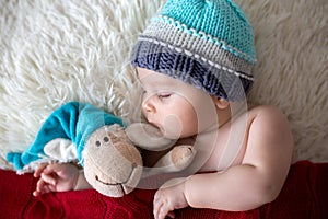 Little sleeping newborn baby boy, wearing Santa hat