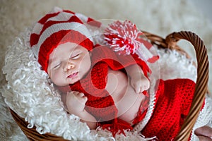 Little sleeping newborn baby boy, wearing Santa hat