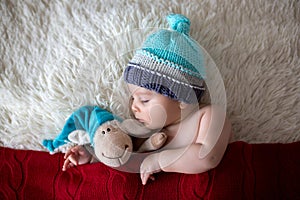 Little sleeping newborn baby boy, wearing Santa hat