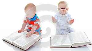 Little smart boy reads a big book.