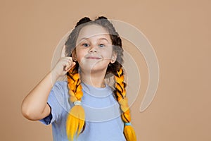 Little smart girl with kanekalon braids of yellow color showing finger having aha moment because of great idea appearing