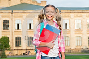 Little smart student. happy preschool girl with folder in school yard. back to school. hardworking child with book