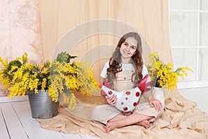 Little smile girl playing with Easter decoration at home. Little child farmer. Easter room interior.