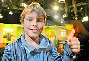 Little smiling boy stands in auditorium