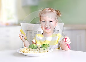 Little smiling girl eating vegetables,healthy food concept