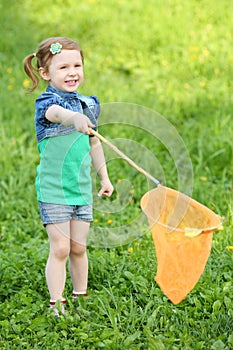 Little smiling girl holds orange butterfly net on