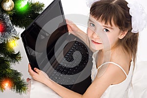 Little smiling girl with laptop computer