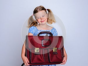 Little smiling girl with old satchel