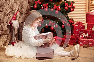 Little smiling girl opens a magic Christmas gift box