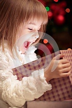 Little smiling girl opens a magic Christmas gift box