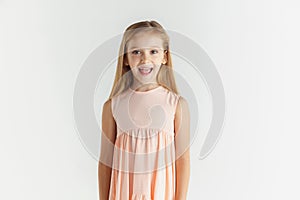 Little smiling girl posing in dress on white studio background