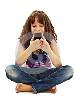 Little smiling girl reading sms on your cell phone